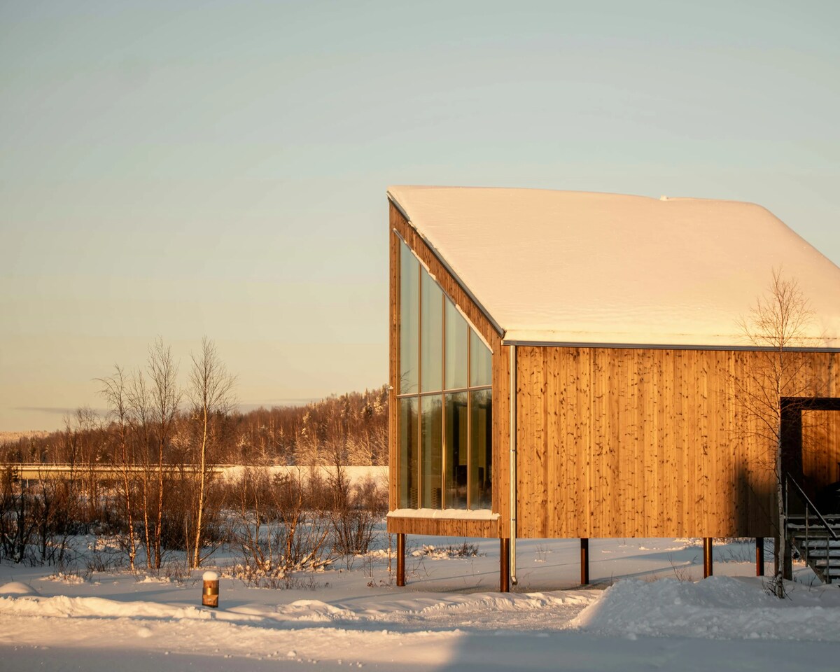 Wooden land accommodation at Arctic Bath in winter