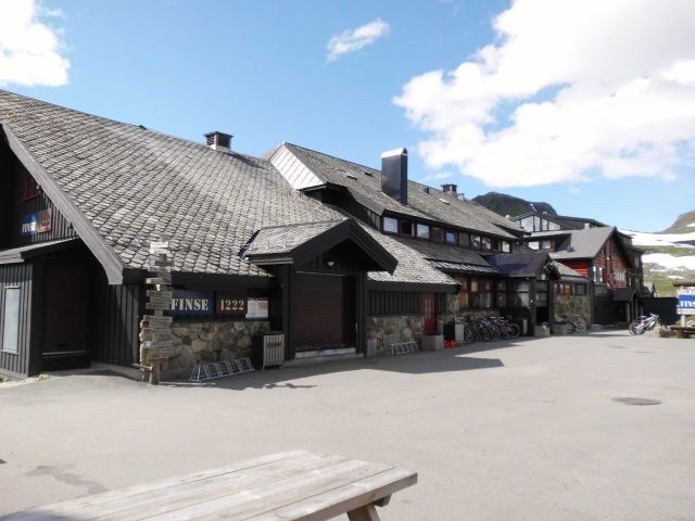 The exterior of Finse 1222 hotel, with its sign, bicycles and a bench.