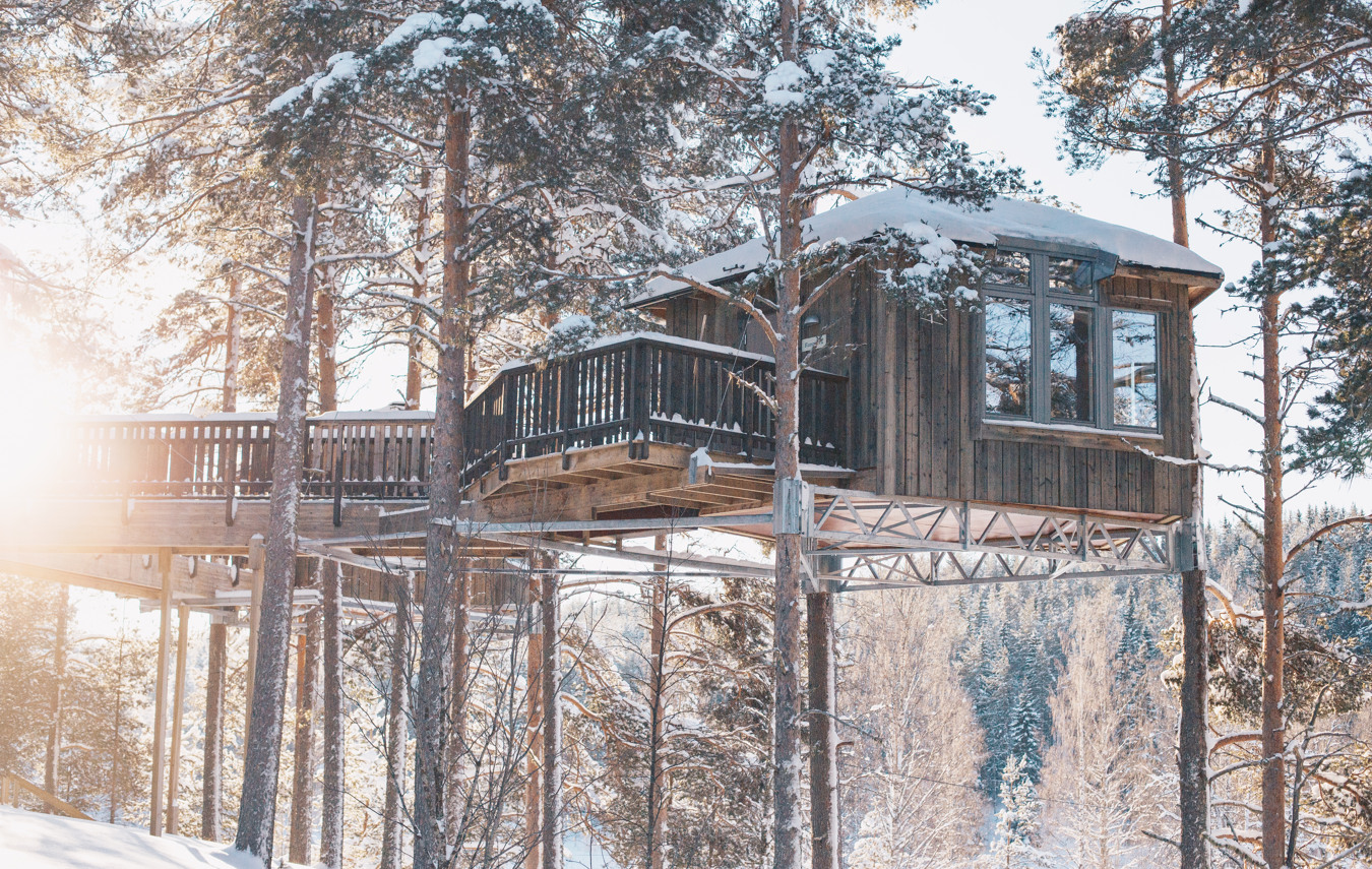 A timber Bird’s Nest room raised among snow-covered pines at Granö Beckasin.