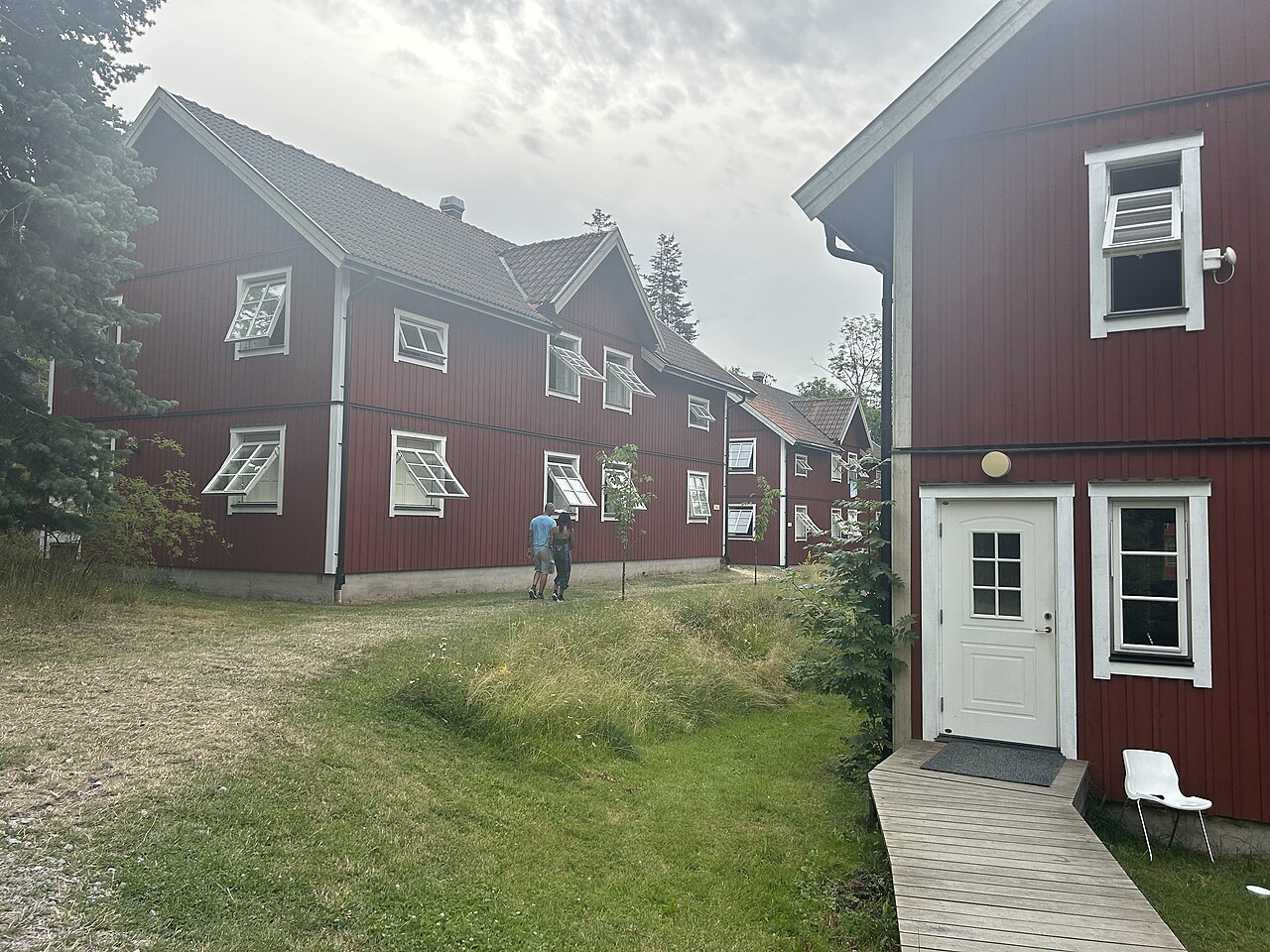 Red timber hotel accommodation buildings with white windows at Grinda Wärdshus.