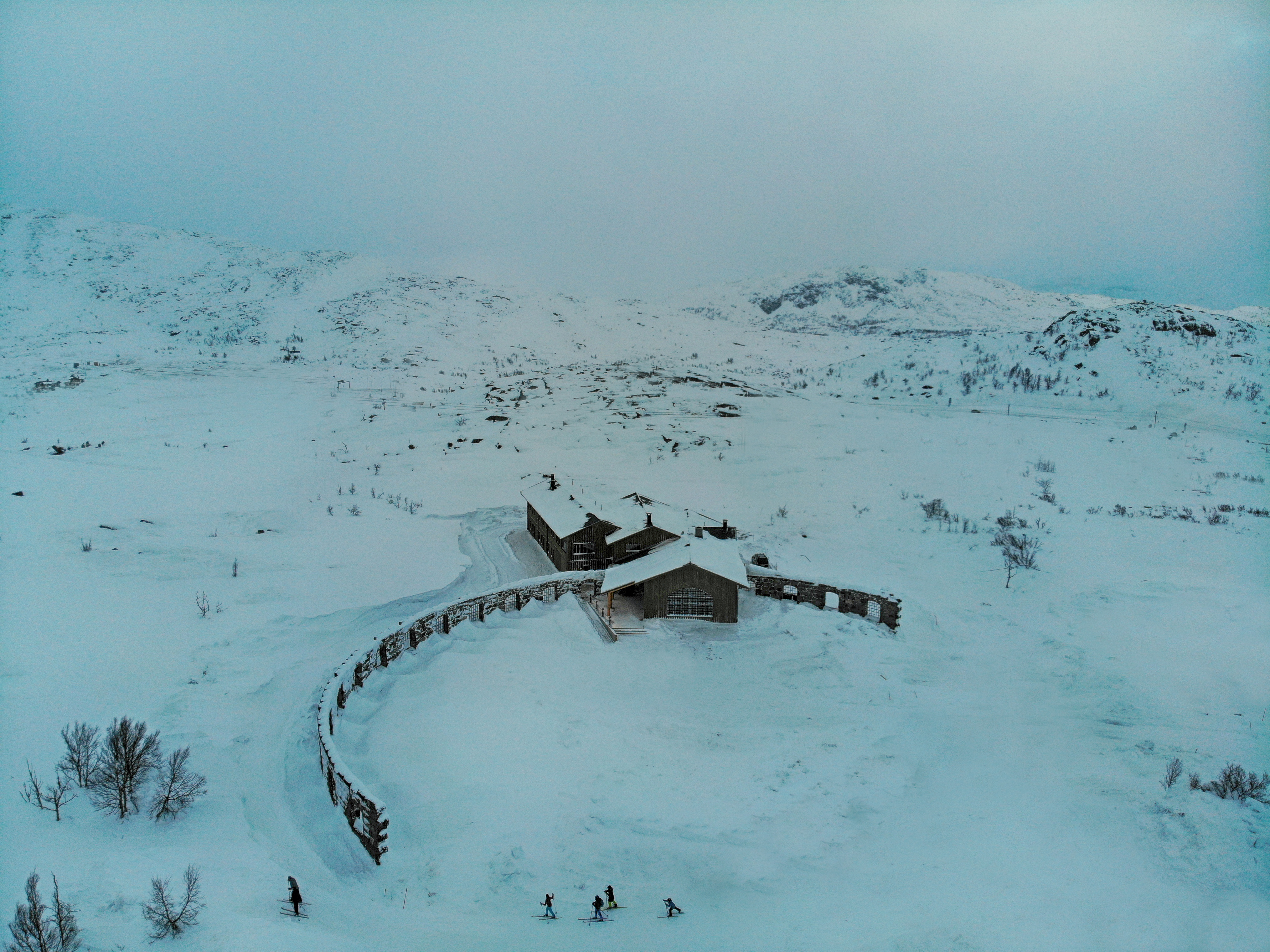 A winter exterior view of Niehku Mountain Villa and the surrounding mountains.