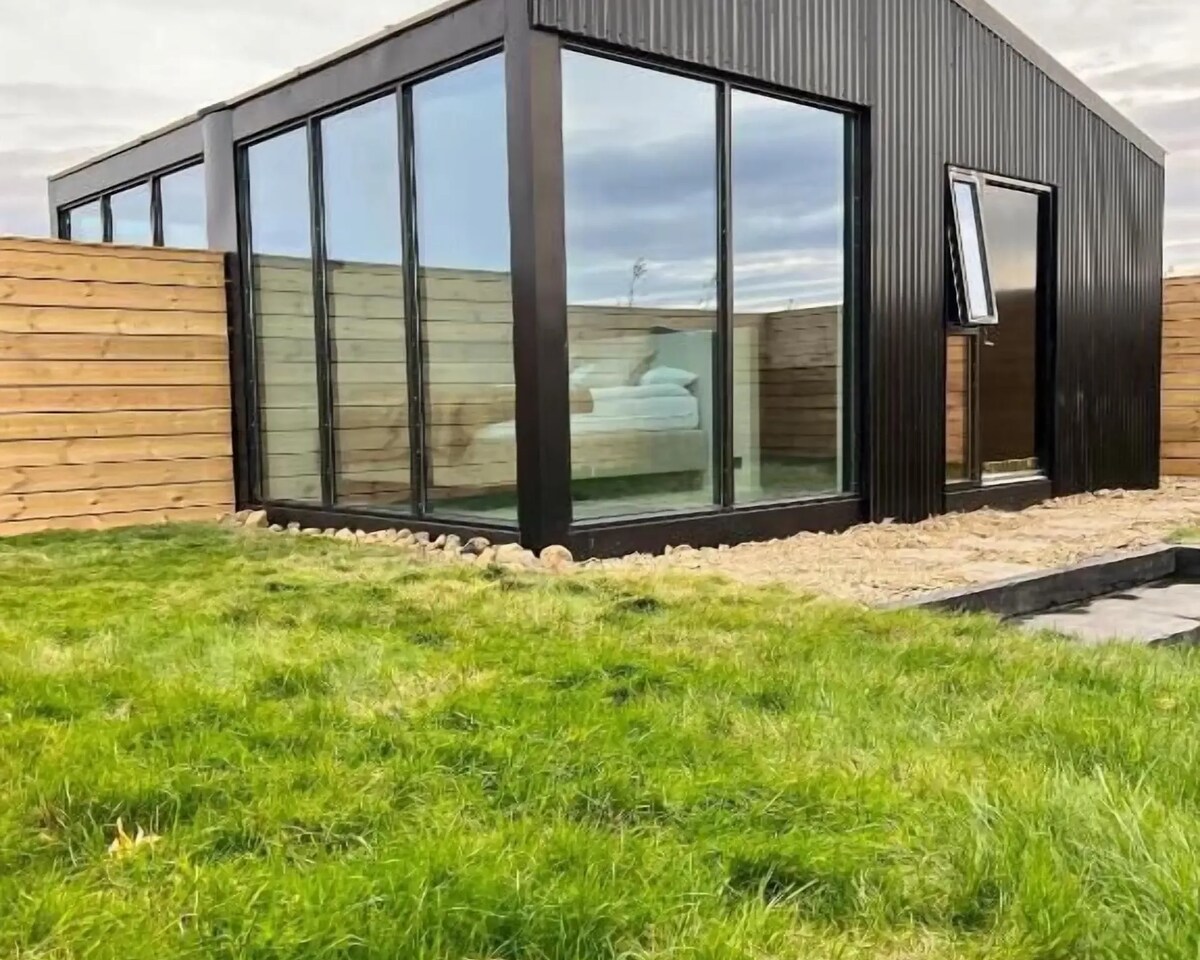 Glass-fronted lodge with a private terrace at Night & Day Lodge