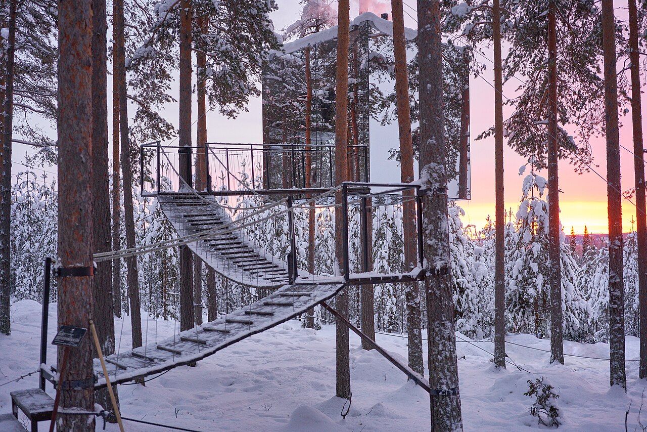 The mirrored walls and suspended walkway of Mirrorcube at Treehotel, Harads, in winter.